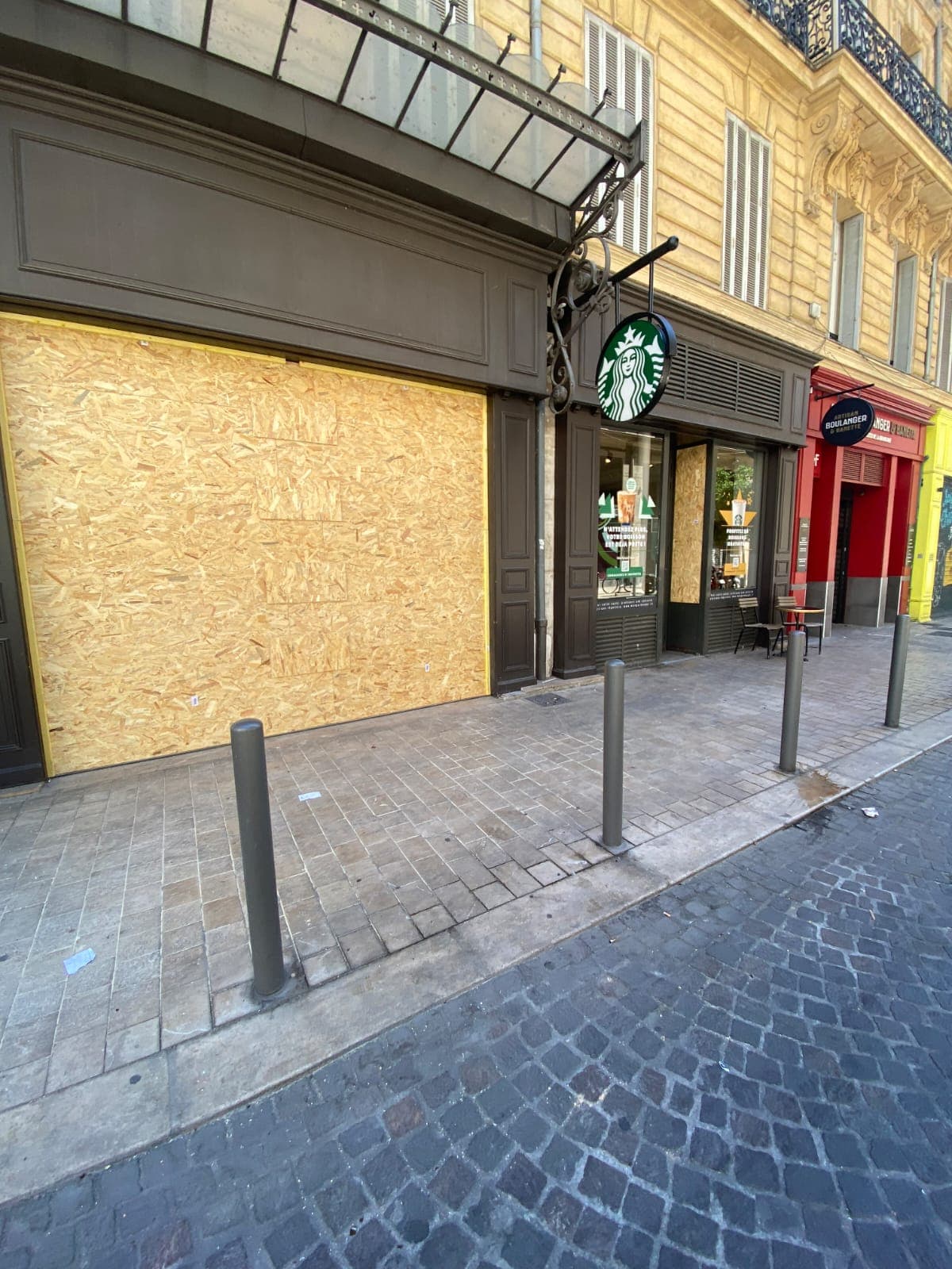 Vitrines d'un café condamnées par des panneaux OSB après dégradations - mise en sécurité BS PRO