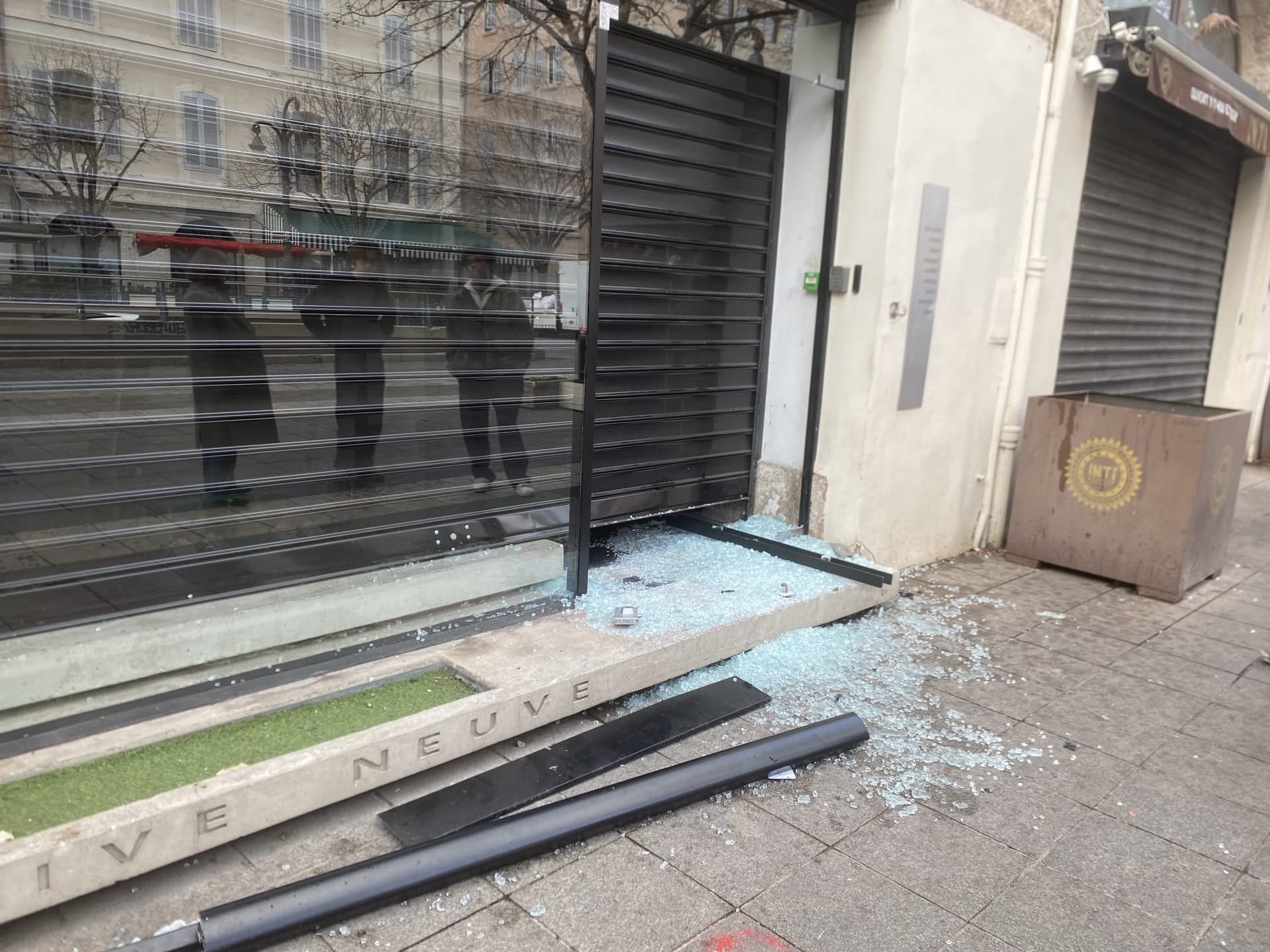 Vitrine de boutique brisée et rideau métallique arraché après des dégradations - intervention BS PRO